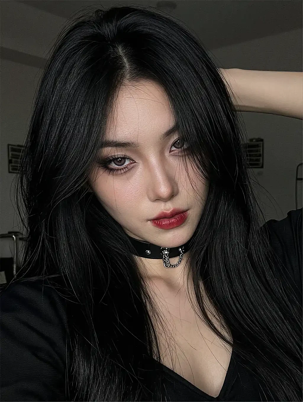 Fictional AI character with long black hair and a choker photographed close up in a dark room